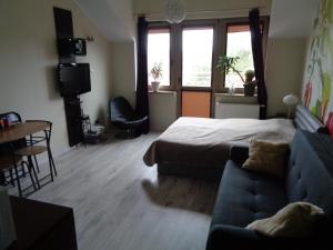 um quarto com uma cama, um sofá e uma mesa em Apartament Happy em Świnoujście