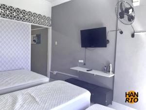 um quarto com uma cama e uma secretária com uma televisão em Have A Nice Rio no Rio de Janeiro