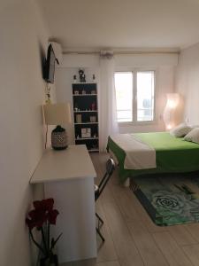 a bedroom with a bed and a desk and a window at Appartement triangle d'or Saint Raphaël in Saint-Raphaël