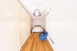 a bedroom with a bed and a blue chair at Figoli guesthouse in Oristano