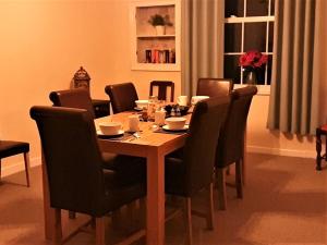 uma mesa de jantar com cadeiras e uma mesa e uma mesa e uma cadeira em Riverbank Guest House em Wiggenhall Saint Germans