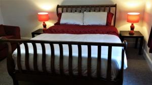 a bedroom with a large bed with two lamps at Riverbank Guest House in Wiggenhall Saint Germans