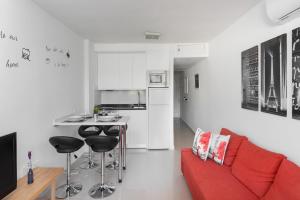 Una sala de estar con un sofá rojo y una cocina. en DANA II Eurogolf, vistas, wifi, piscina y parking, en Benalmádena
