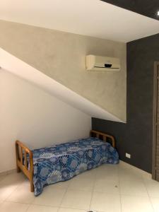 a bedroom with a bed with a blue comforter at Villa Alfonso con vista mare in Siculiana Marina