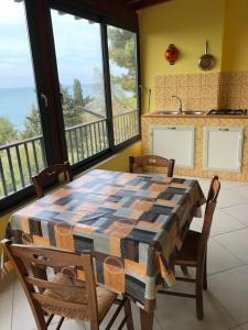 a table and chairs in a room with a balcony at Villa Alfonso con vista mare in Siculiana Marina