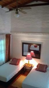 - 2 lits dans une chambre avec une lampe et un miroir dans l'établissement Villa de las Palmas de Rozo Palmira, à Rozo