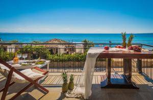 a table on a balcony with a view of the ocean at Anastasia Miramar Deluxe Apartments in Zakynthos