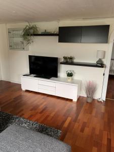 a living room with a tv and a white entertainment center at Villa Toften in Skanderborg