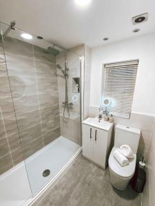 a bathroom with a shower and a toilet and a sink at Sutton Heath Lodge in Saint Helens