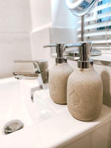 two soap dispensers sitting on a bathroom sink at Sutton Heath Lodge in Saint Helens