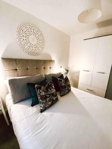 1 dormitorio con 1 cama blanca grande con almohadas en Sutton Heath Lodge en Saint Helens