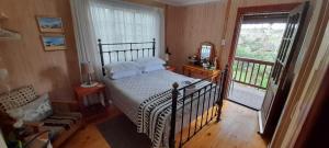 a bedroom with a bed and a balcony at Kattekwaad Accommodation in Kaapsehoop
