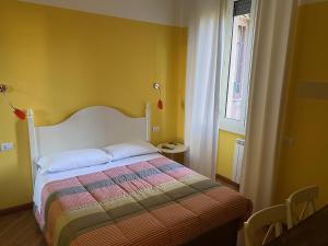a bedroom with a bed in a yellow room at Luna Rossa Roma Guest House in Rome