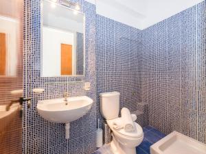 een blauw betegelde badkamer met een toilet en een wastafel bij Anastasia Miramar Deluxe Apartments in Zakynthos