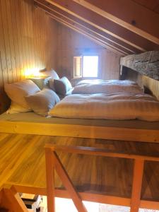 a large bed in a room with a wooden wall at Charmant Chalet mit See und Bergsicht in Hofstetten 