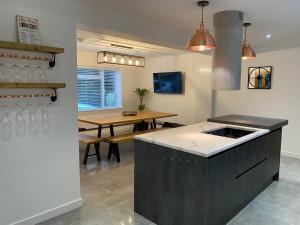 eine Küche mit einer Theke und einem Tisch darin in der Unterkunft Rhos Walia,near Snowdonia,Hot tub in Caernarfon