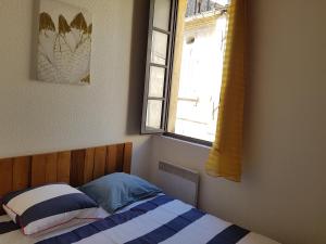 a small bedroom with a bed with a window at Appartement Roquette Serenity in Arles