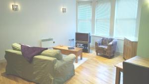uma sala de estar com um sofá e uma cadeira e uma televisão em Easby Hall 24 em Scarborough