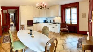 uma cozinha com uma grande mesa branca e cadeiras em l'Attique du Château em Cormondreche