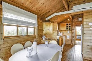 een eetkamer met een witte tafel en stoelen bij Cozy house with stunning sea views in Pandrup