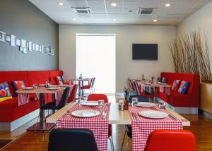 a restaurant with red chairs and tables and a tv at Ibis Istanbul Esenyurt in Istanbul