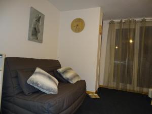 a living room with a brown couch with pillows on it at L'AnsloBoys Montagne A2 in Les Deux Alpes