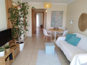 een woonkamer met een witte bank en een tafel bij Casas do Mar - Baleal 1 - Sea House in Baleal