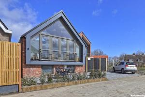 una casa con una gran ventana en el lateral en NIEUW! Vakantiehuis Singel 3A met SAUNA - baddomburg, en Domburg