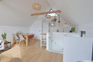 a white kitchen with a table and a dining room at NIEUW! Vakantiehuis Singel 3A met SAUNA - baddomburg in Domburg