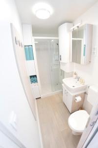 a white bathroom with a toilet and a shower at Adria Portorož Luxury Houseboat in Portorož