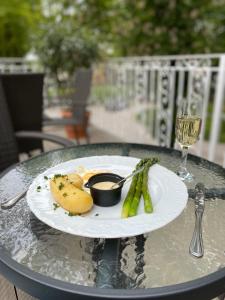 a plate of food on a table with a glass of wine at Hotelik Polonia in Łowicz
