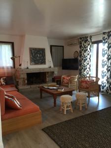 een woonkamer met een bank en een open haard bij Résidence Casa Favalella in Porto Pollo