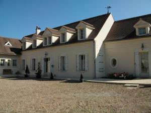 a large white building with a black roof at Ferme De La Canardière in Chantilly