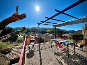 un patio con tavolo e sedie su un balcone di Cottage du Capiol en Périgord a Cénac-et-Saint-Julien