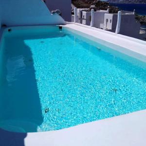 una piscina con agua azul en una casa en 4BD Blue Dream Mykonos, en Mykonos ciudad