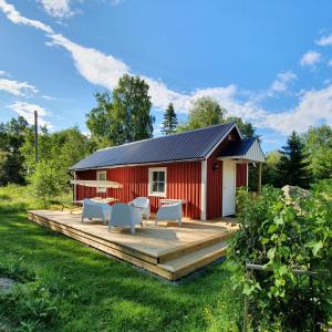 a red barn with a wooden deck in the yard at Guesthouse 'Lodge Lagom' ~ Hammarstrand-Jämtland in Hammarstrand