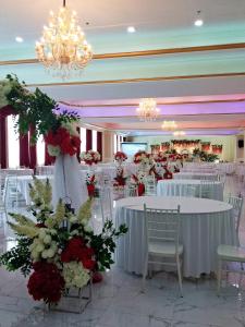 a banquet hall with white tables and red and white flowers at Kampar Champs Elysees, King Bed Studio unit 12A21 in Kampar