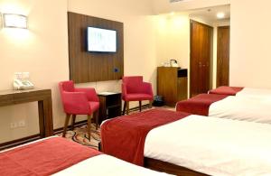 فندق حياة الذهبي في المدينة المنورة: غرفة فندقية بسريرين وكرسيين احمر