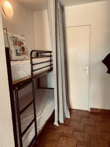- une petite chambre avec des lits superposés et une porte dans l'établissement Joli studio cabine 2 à 4 pers, bord de mer, Port Camargue, La Croisière, au Grau-du-Roi