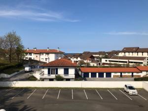 a parking lot with a car parked in a parking lot at Appartement lumineux, avec balcon, à 200m de la plage in Hendaye