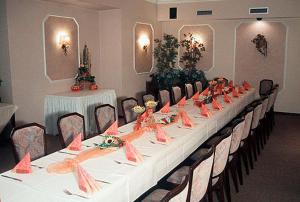 a long table in a room with tables and chairs at Hotel Alex Herbermann in Glandorf