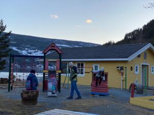 un groupe de personnes jouant sur une aire de jeux dans l'établissement Sandviken Camping, à Austbygdi