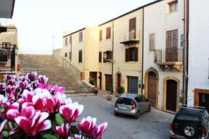 een auto geparkeerd op een parkeerplaats met roze bloemen bij Casa Belvedere in Sambuca di Sicilia