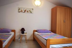 a bedroom with two twin beds and a cabinet at Apartmenthaus Mira Eldic in Fažana