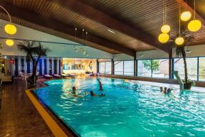 a large swimming pool with people in the water at Ferienwohnungen Am Skilift in Herrischried