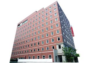 a large red brick building with many windows at Tourist Inn Kochi in Kochi