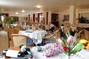 restauracja ze stołami i krzesłami z kwiatami w obiekcie Hotel Villa Rosa w mieście Martina Franca