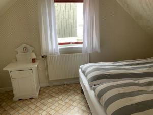 een slaapkamer met een bed en een raam bij Cosy old house Vágar next to Mykines in Sørvágur