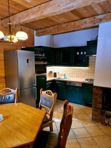 ベトリナにあるKURNACHATAのキッチン(緑のキャビネット、テーブル、冷蔵庫付)