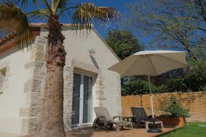 patio con tavolo e ombrellone di Petite Maison refaite à neuf proche plage a Mèze